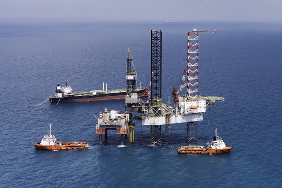 An offshore drilling rig with several vessels.