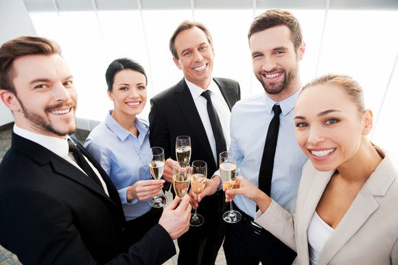 Professionals raising champagne glasses
