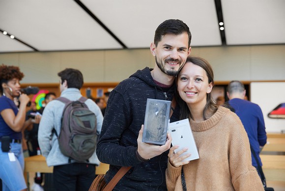 A man and woman holding new iPhones.
