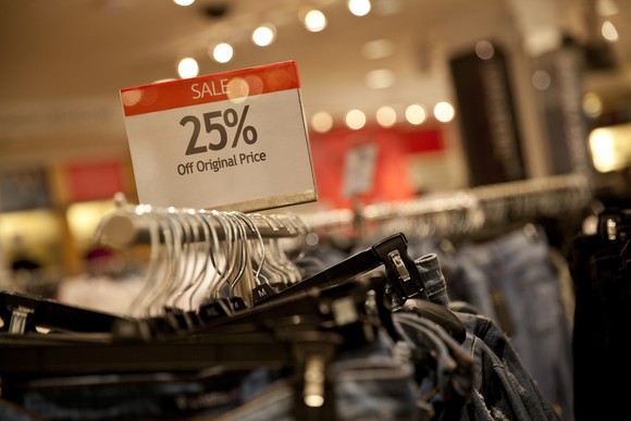 25 percent off sign above a rack of jeans in a store