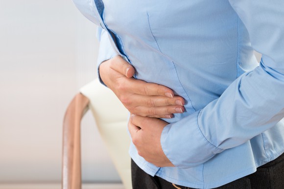 Woman's torso while she holds her stomach