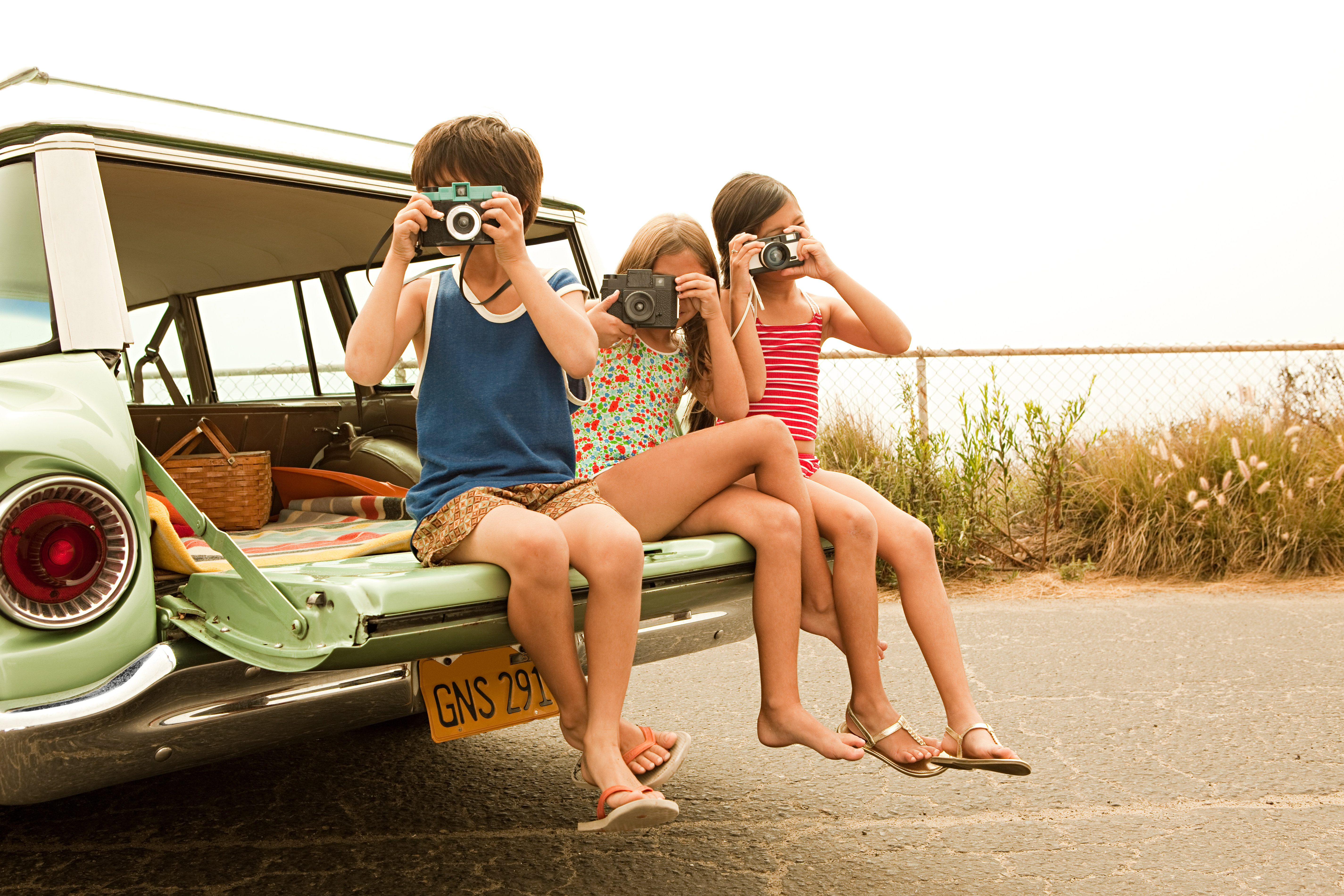 Three kids taking photos.