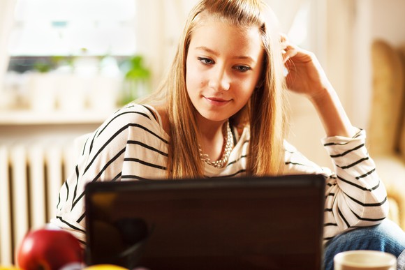 Teen girl looking at laptop