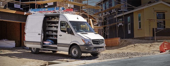 A white Mercedes Benz Sprinter van pulled up at the construction site of a new housing development.