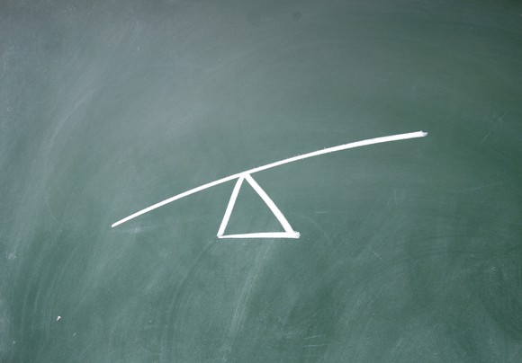 A drawing on a chalkboard of a triangle with a line balanced on top, meant to demonstrate leverage.