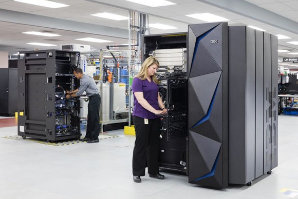 Two people working on IBM z14 mainframe systems.