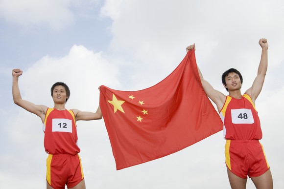 Two athletes holding the Chinese flag between them