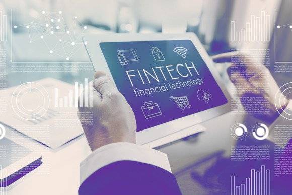 A man holding a tablet that reads "FINTECH financial technology".