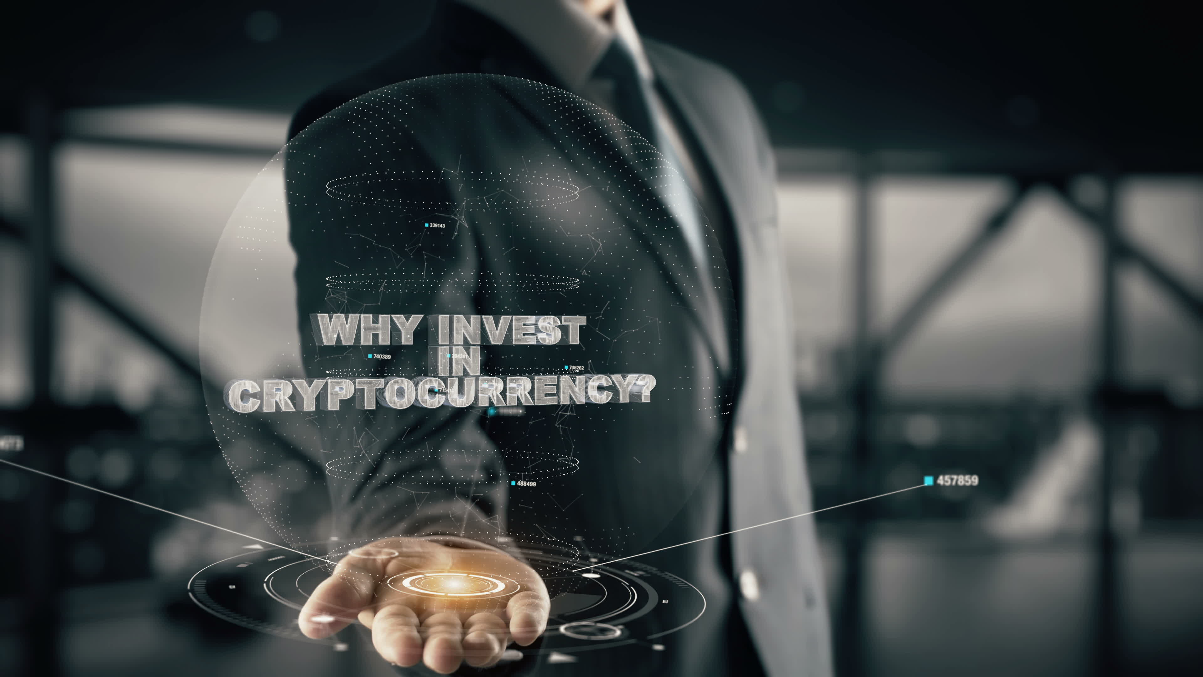 Man in suit holding out hand with computer graphics extending from open hand. Reads "Why invest in cryptocurrency?" across the picture.