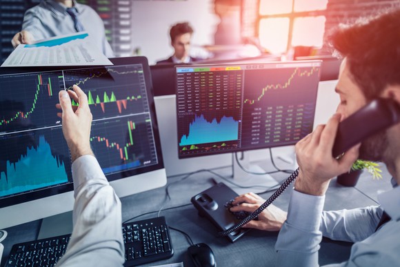 Stock traders working at a trading desk.