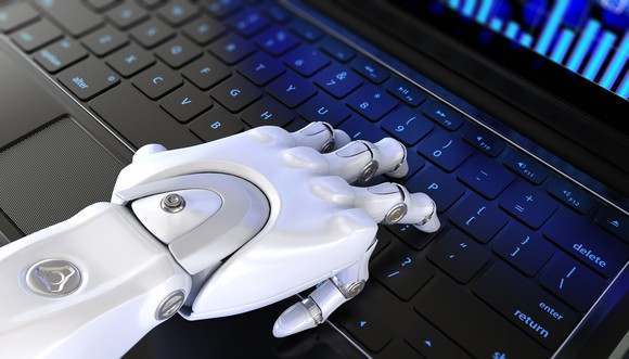 A robot hand on a laptop keyboard.