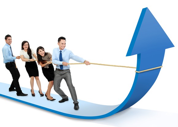 Four people pulling rope to bend arrow upwards