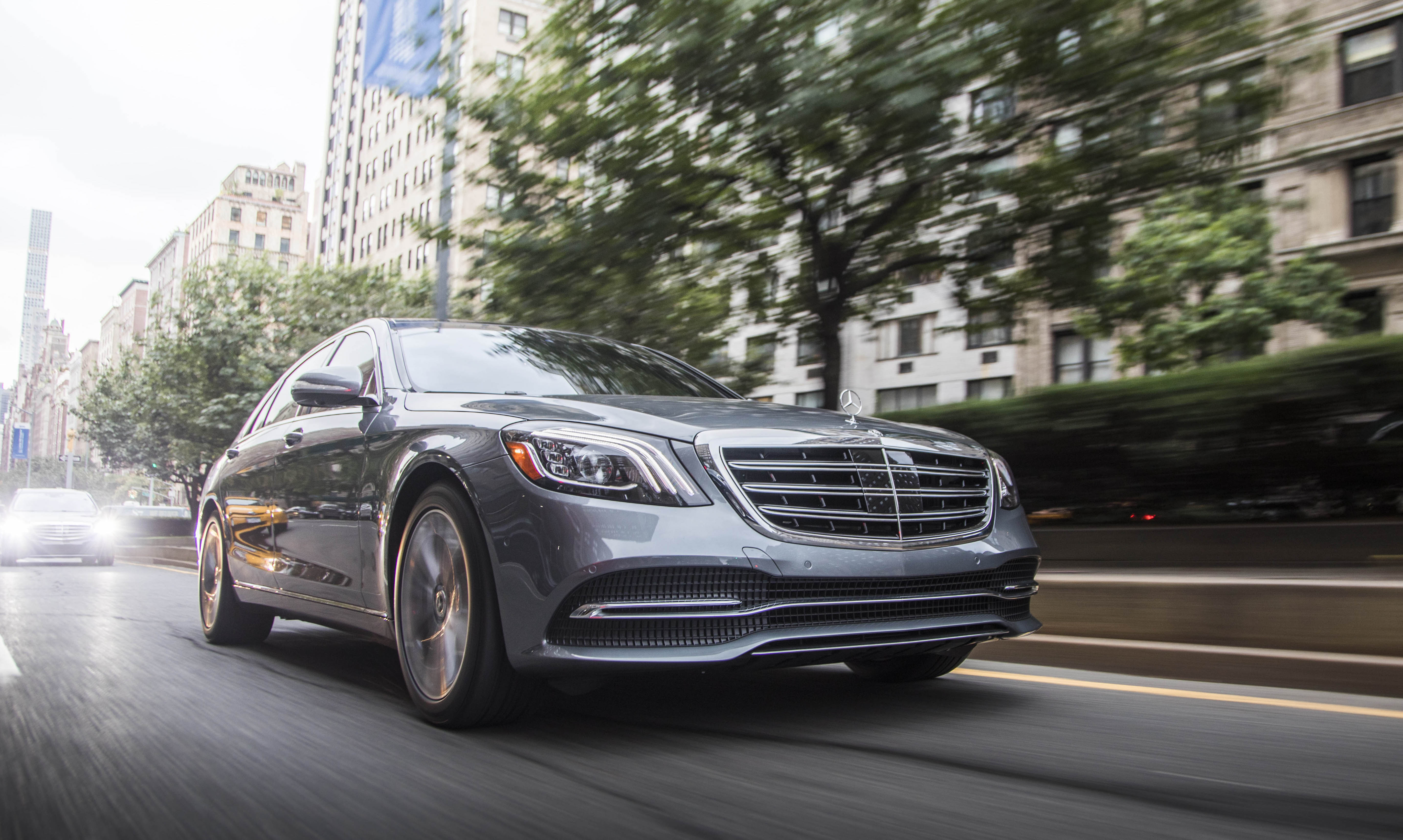 A silver 2018 Mercedes-Benz S450, a big four-door luxury sedan, on a city street.