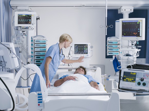 Nurse tending to patient in hopsital bed
