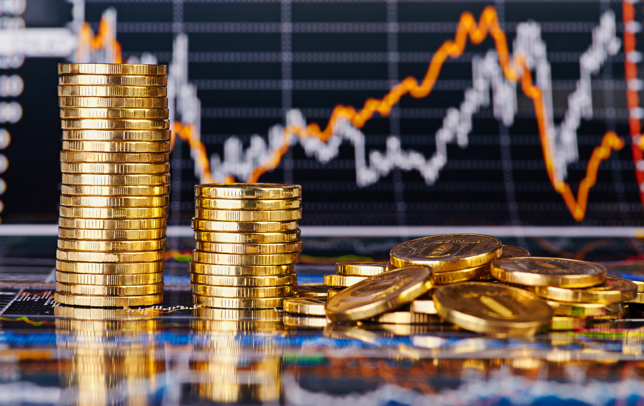 Coins in front of a stock chart