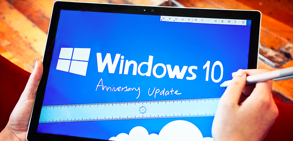 The Microsoft Windows 10 logo shown above the words Anniversary Update on a Surface Tablet