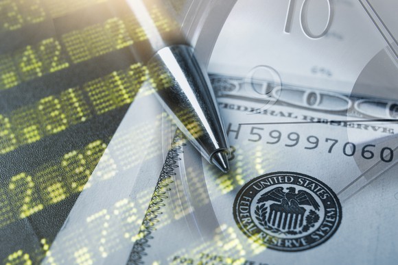 Stock index board, $100 bill, and clock all superimposed on top of each other.