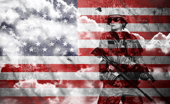 Soldier with rifle against an American flag