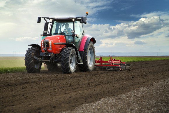 A man drives a tractor through a field.