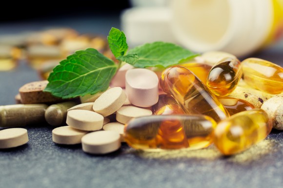 Pile of vitamins spilling out of a bottle
