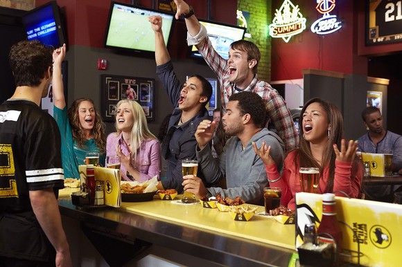 Diners cheering a game at a Buffalo Wild Wings bar