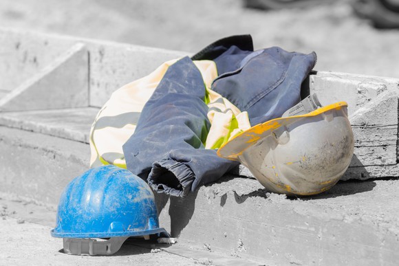 Hard hats and jacket on the ground.