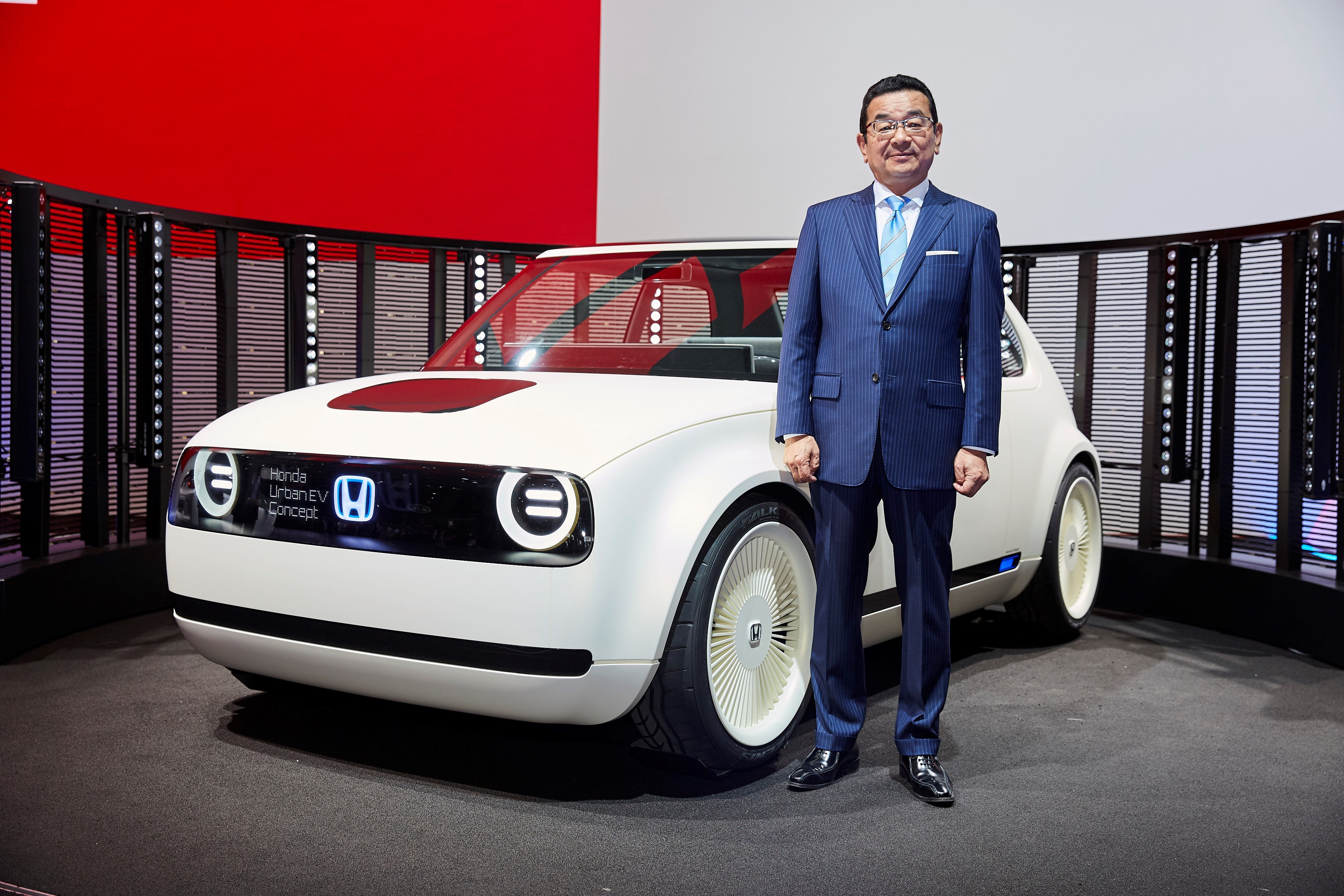 Hachigo is shown standing next to Honda's Urban EV Concept on Honda's auto-show stand in Frankfurt in September 2017.