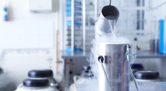 Liquid nitrogen being poured into a storage container.