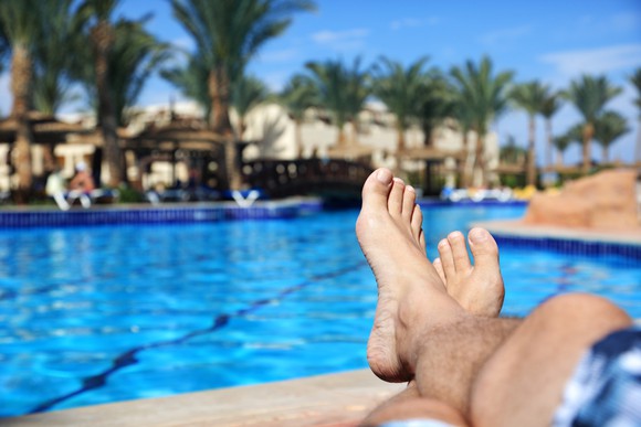 Man's feet next to a sparkling pool