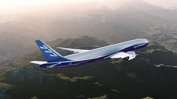 A 777-300ER flying over mountainous terrain
