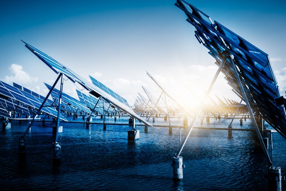 Solar panels with a bright sun in the background.