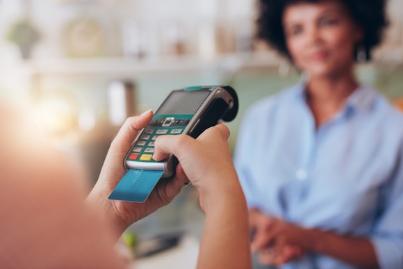 Credit card sticking out of handheld card reader