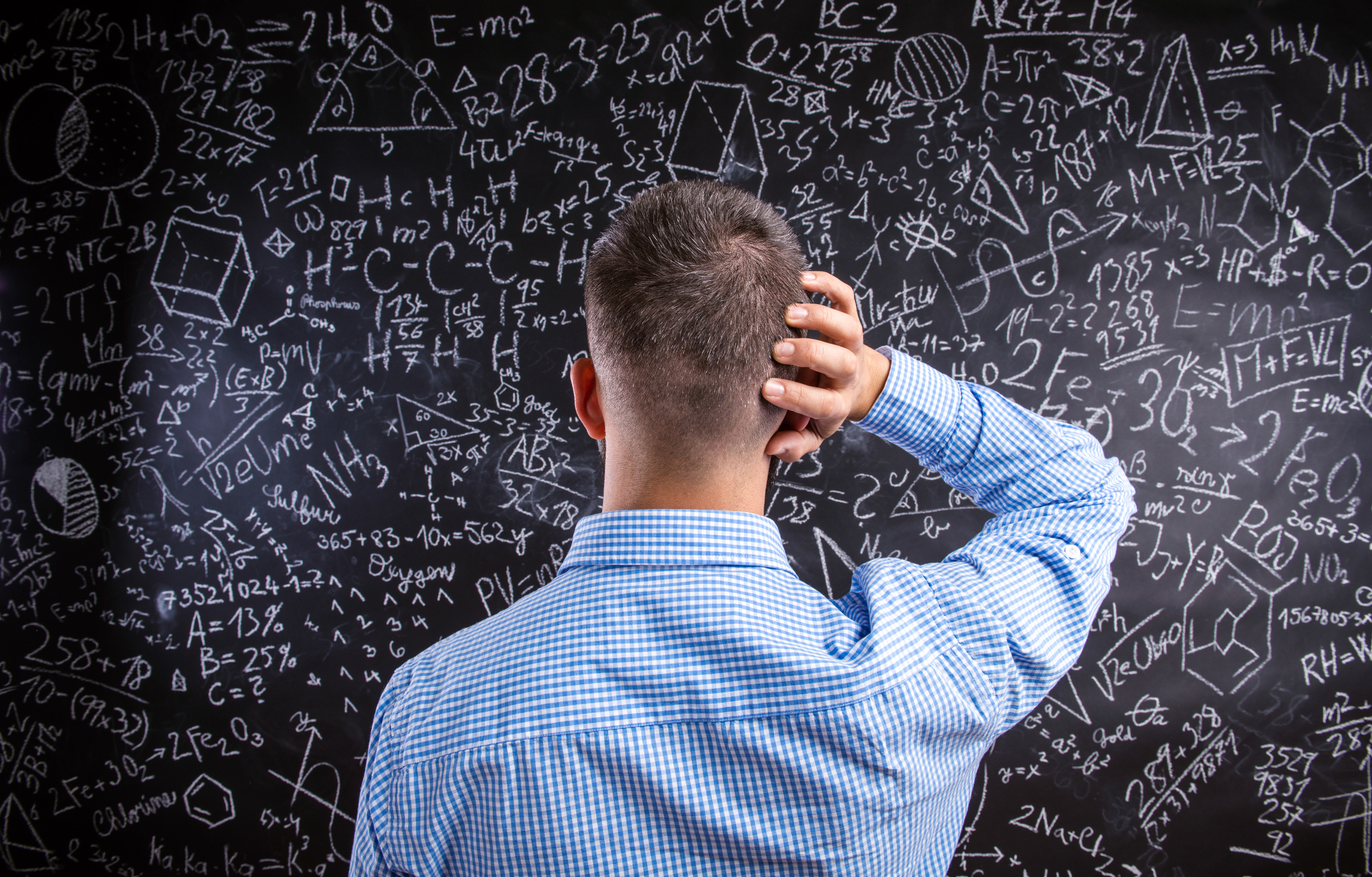 Confused man staring at blackboard