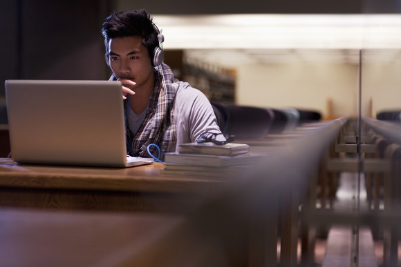 A student working on a computer in a library.