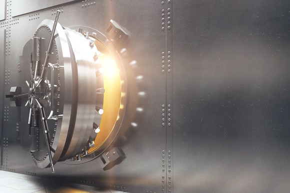 Bank vault door opening with light coming from inside.