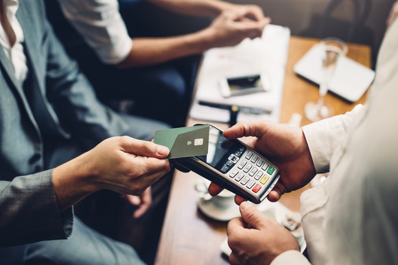 A credit card being scanned with a handheld device