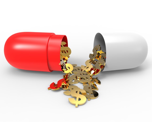 Two parts of capsule with gold dollar symbols overflowing out of the capsule