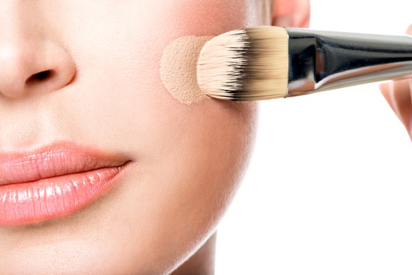 A woman putting foundation on her face