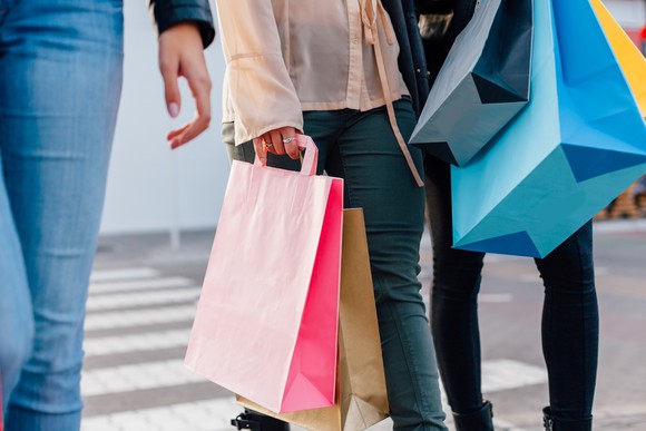 A woman holds shopping bags.