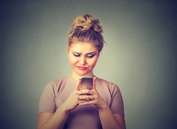 Woman looking skeptically at her phone.