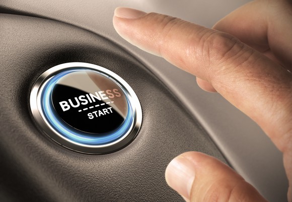 A person pushing a button with the words business and start on it