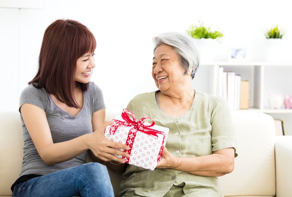 A woman gives a present to her mother.