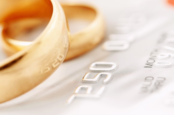 two gold wedding rings resting on part of a credit card