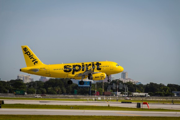 Exterior of landing Spirit A319 in bright yellow livery.