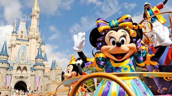 Minnie Mouse waving with Mickey Mouse and the Disney Castle in background