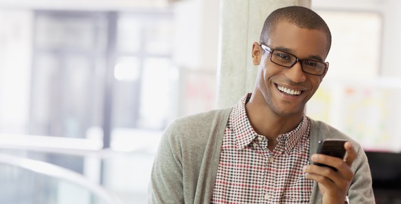 Man holding smartphone and smiling