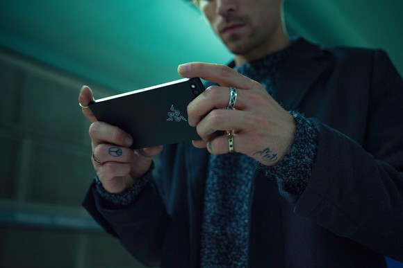 A man holding and looking at the Razer Phone.