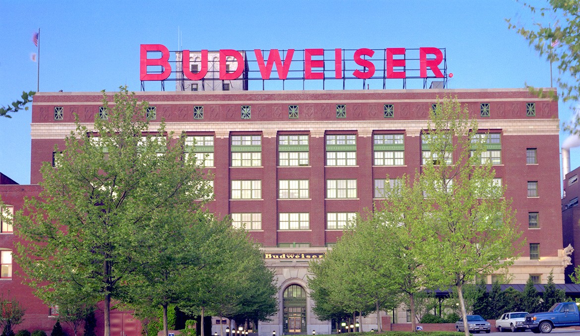 The front of a Budweiser factory, an old six-story brick building with the Budweiser name displayed on top.