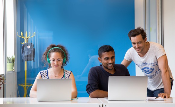 Smiling Wix employees working on laptops