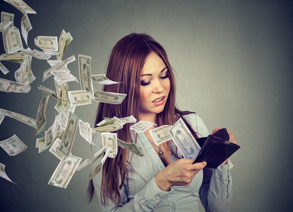 Money flying out of a woman's wallet